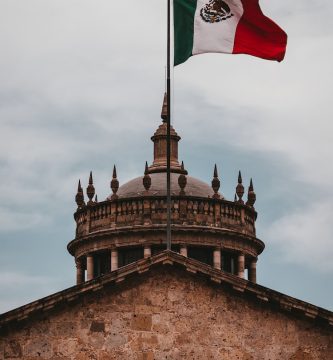 a mexican flag flying on top of a building
